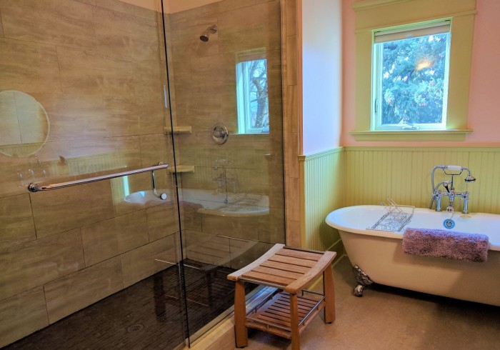 A bathroom with a shower, bathtub, and window