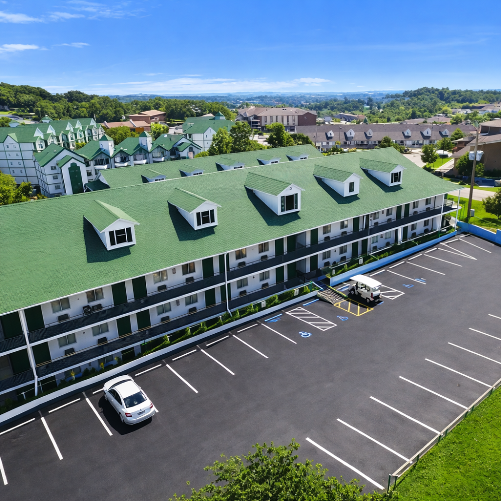 Aerial view of a multi-story building with green roof and parking lot.