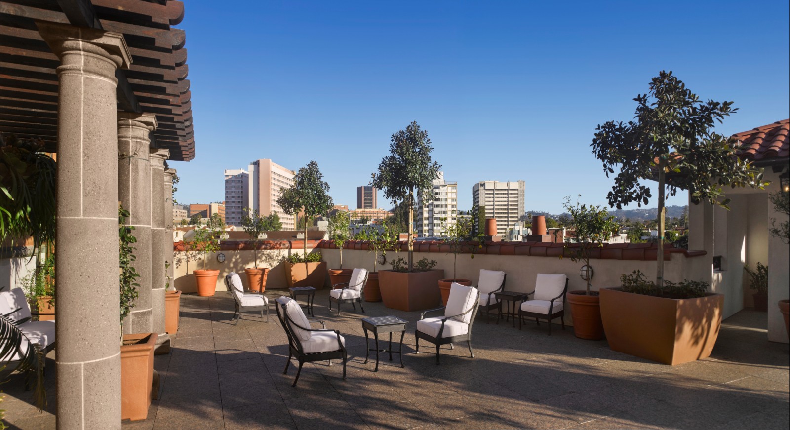 A rooftop patio with outdoor seating and a city view.